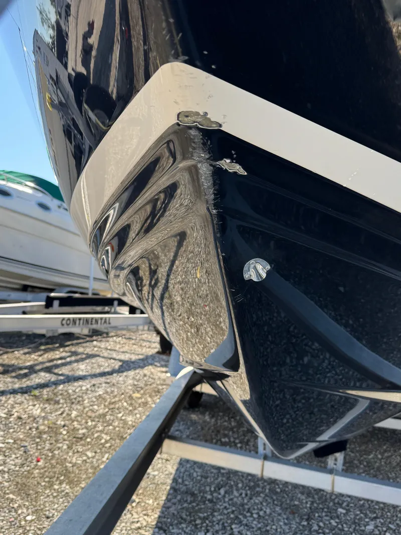 Slide: The Image of 2013 Regal 2500 Bowrider boat with visible hull damage on trailer. - 5