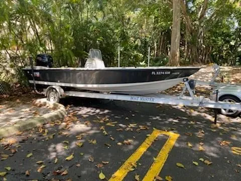 Slide: The Image of 2001 Hewes 19 boat on a trailer in a wooded area. - 0