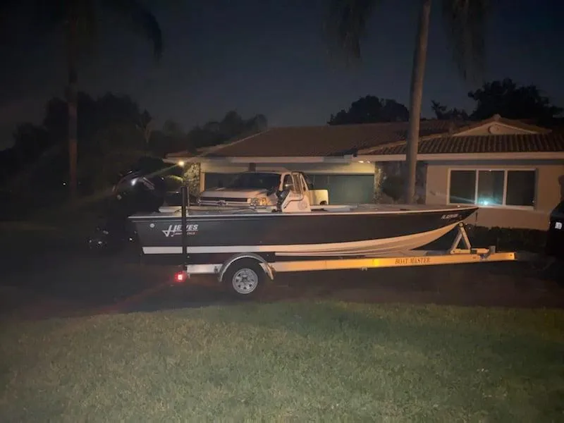 Slide: The Image of 2001 Hewes 19 boat on trailer parked in front of a house at night. - 1