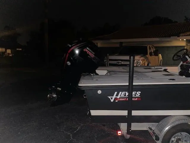 Slide: The Image of 2001 Hewes 19 boat with outboard motor on trailer at night. - 2