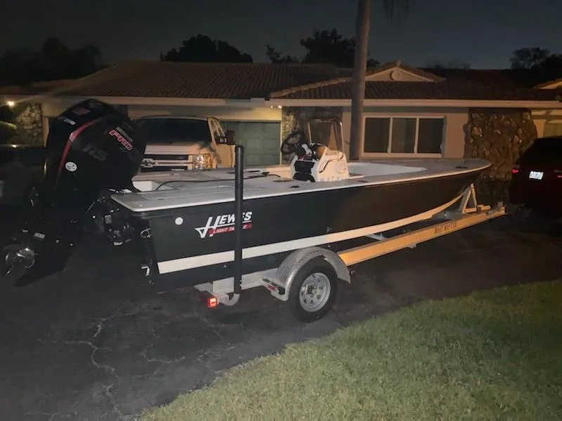 Slide: The Image of 2001 Hewes 19 boat on trailer parked in driveway at night. - 3