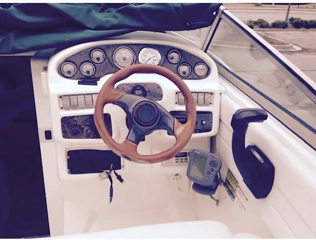 Slide: The Image of 1998 Doral 2500 SC boat dashboard with steering wheel and control panel. - 7