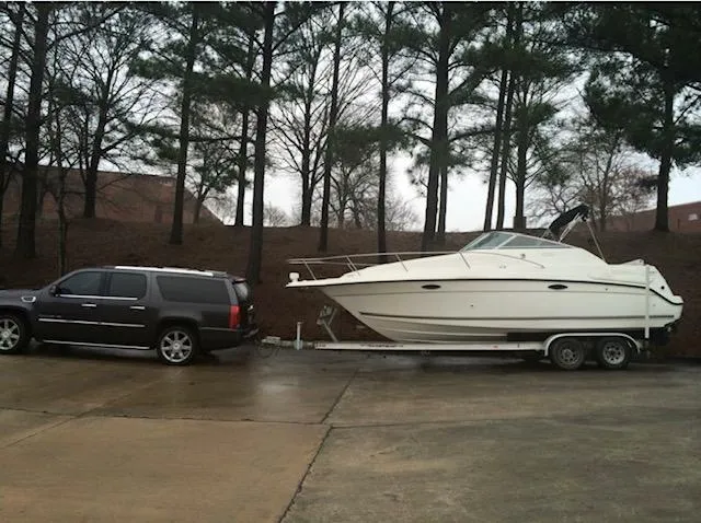 Slide: The Image of SUV towing a 1998 Doral 2500 SC boat on a trailer in a wooded area. - 8