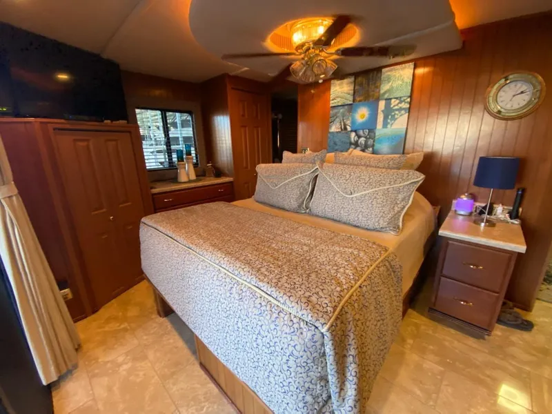 Slide: The Image of Luxurious bedroom interior of a 2003 Monticello River Yacht with elegant bedding and wooden decor. - 10