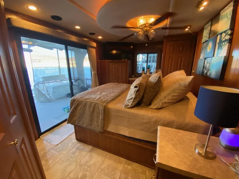 Slide: The Image of Luxurious bedroom interior of a 2003 Monticello River Yacht with a scenic water view. - 11