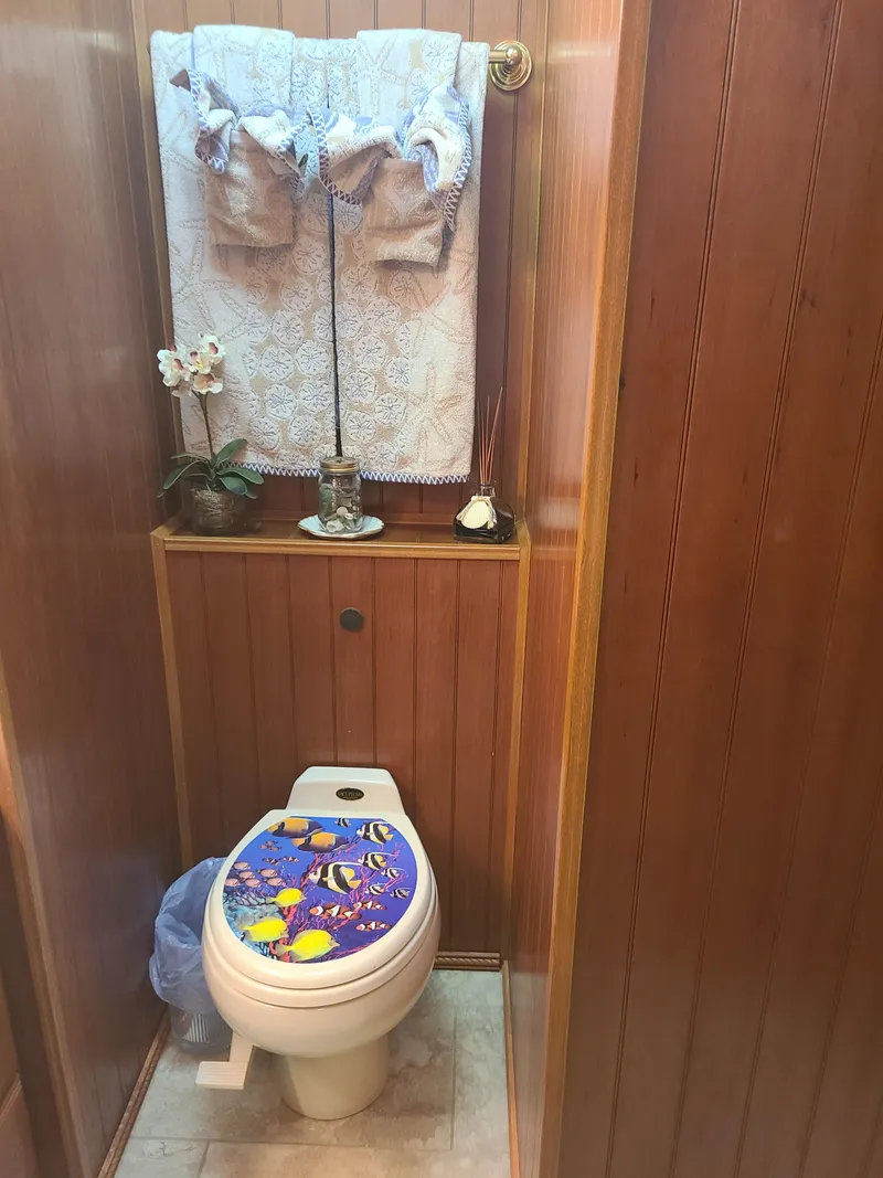 Slide: The Image of 2003 Monticello River Yacht bathroom with wooden paneling and decorative toilet seat. - 13