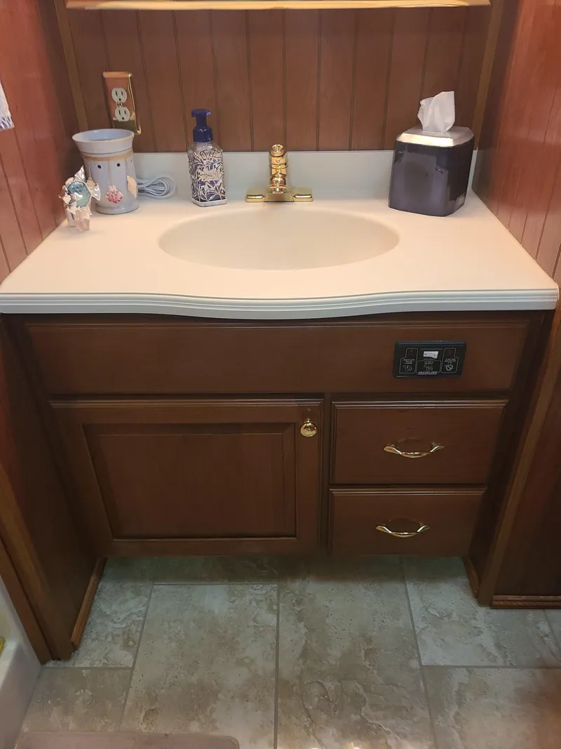 Slide: The Image of 2003 Monticello River Yacht bathroom sink with wooden cabinetry and gold faucet. - 14