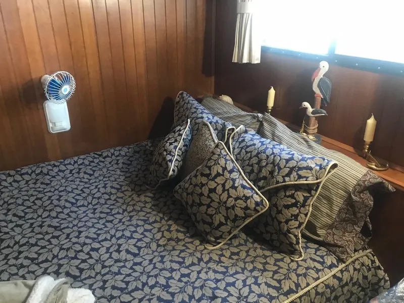 Slide: The Image of Cozy bedroom in a 2003 Monticello River Yacht with decorative pillows and wooden paneling. - 16