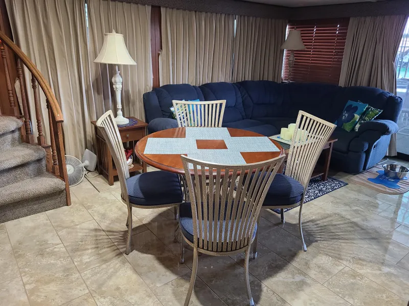 Slide: The Image of Interior of a 2003 Monticello River Yacht with dining table and cozy seating area. - 22