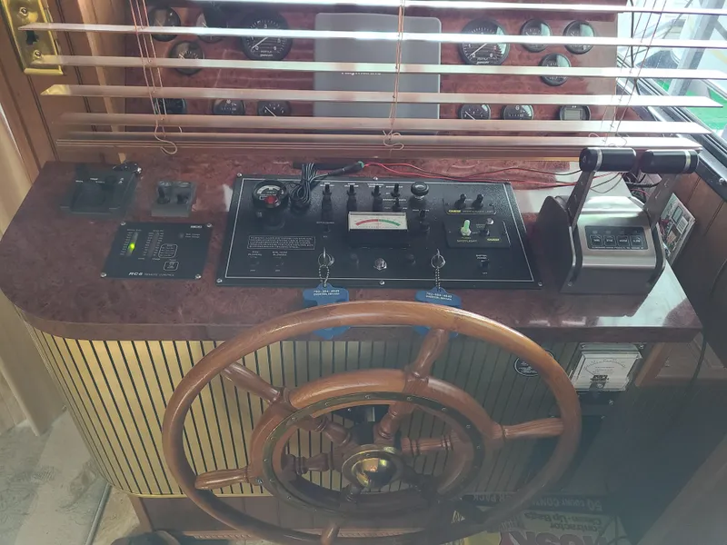 Slide: The Image of 2003 Monticello River Yacht helm with wooden steering wheel and control panel. - 23