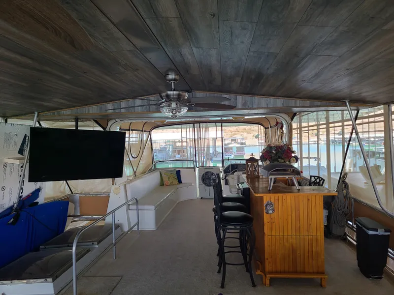 Slide: The Image of Interior of a 2003 Monticello River Yacht with seating, TV, and bar area. - 25
