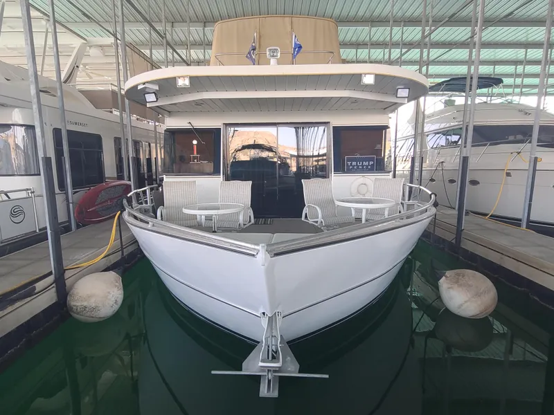 Slide: The Image of 2003 Monticello River Yacht docked in a marina, front view with seating area. - 3