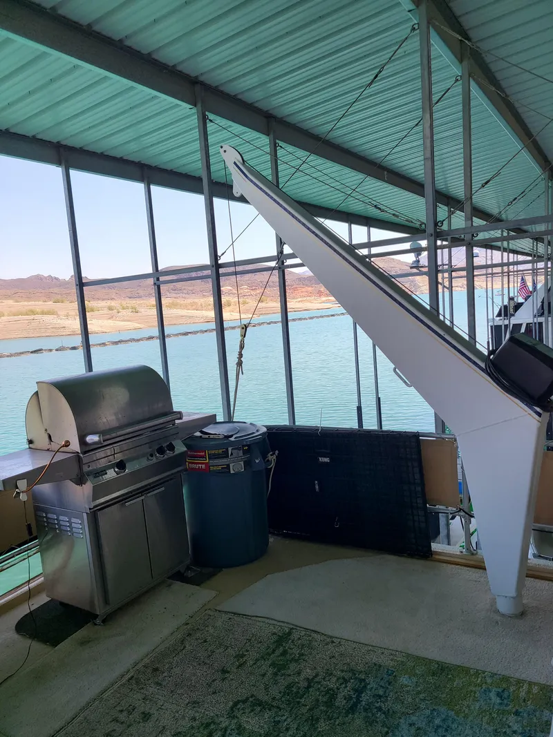 Slide: The Image of 2003 Monticello River Yacht with grill on deck, docked by scenic water. - 31