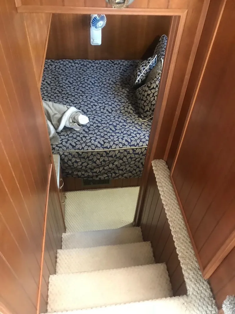 Slide: The Image of 2003 Monticello River Yacht cozy cabin with stairs and patterned bedding. - 35