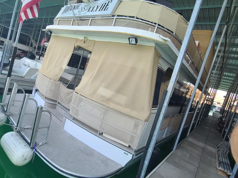 Slide: The Image of 2003 Monticello River Yacht docked with beige canvas covers and American flag. - 5