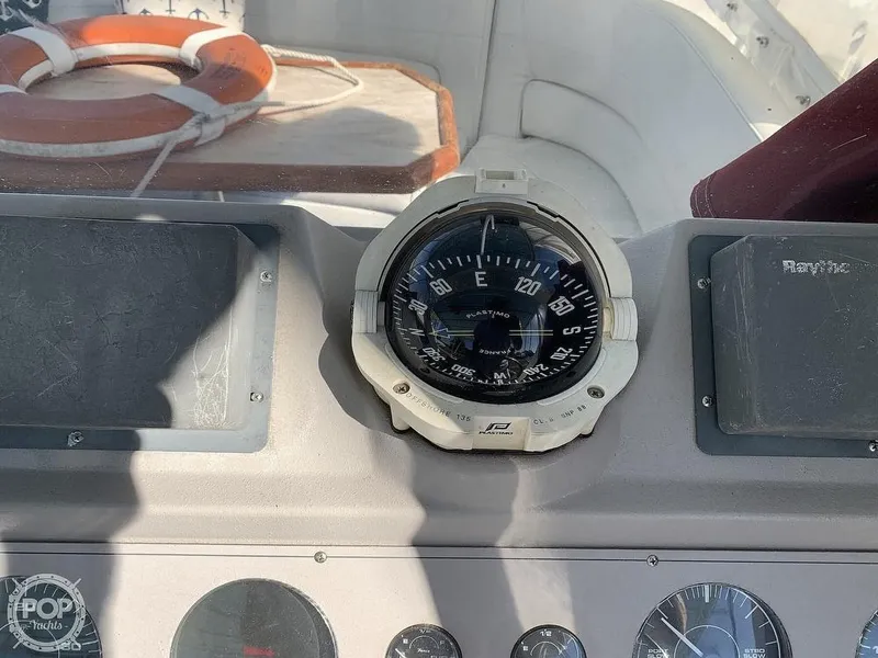 Slide: The Image of 1994 Cruisers Yachts Express Bridge compass and dashboard with life preserver in background. - 11