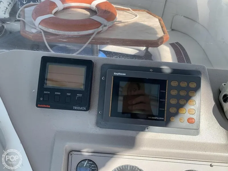 Slide: The Image of 1994 Cruisers Yachts Express Bridge dashboard with Raytheon navigation and Autohelm Tridata displays. - 12