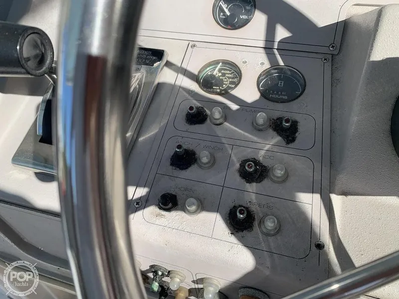Slide: The Image of 1994 Cruisers Yachts Express Bridge control panel with gauges and switches. - 14