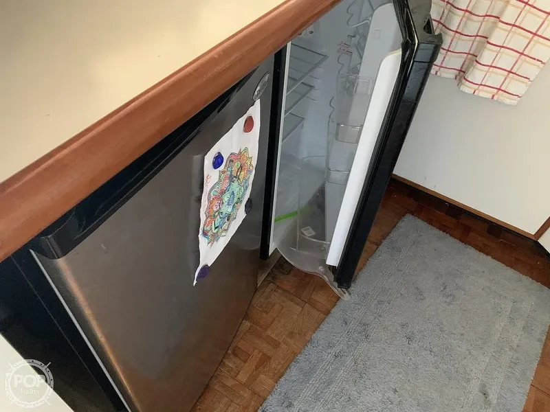 Slide: The Image of 1994 Cruisers Yachts Express Bridge kitchen with open refrigerator and artwork on the door. - 34