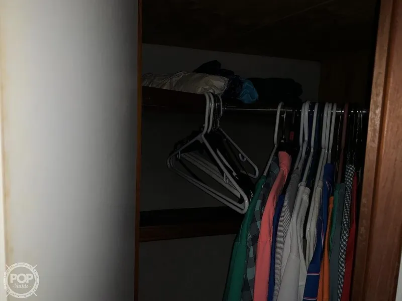 Slide: The Image of Closet inside a 1994 Cruisers Yachts Express Bridge with hanging clothes and shelves. - 42