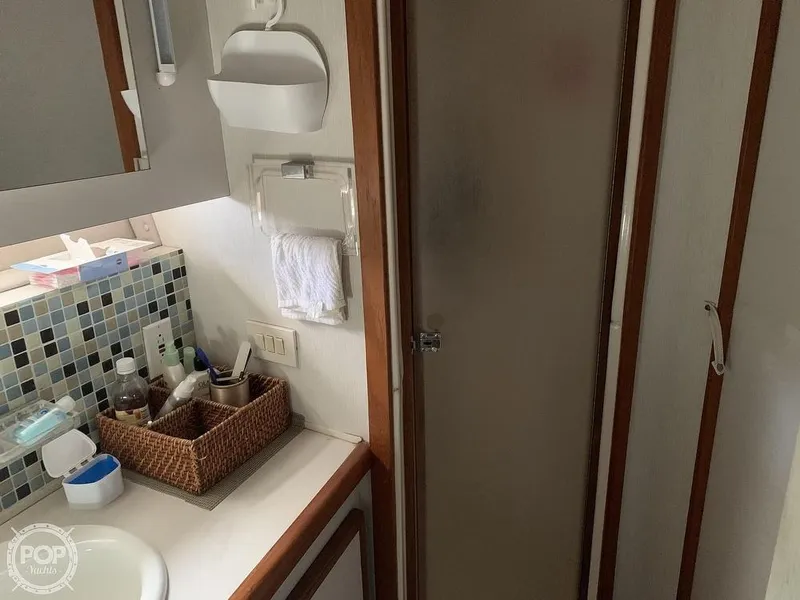 Slide: The Image of 1994 Cruisers Yachts Express Bridge bathroom with shower, sink, and storage baskets. - 49