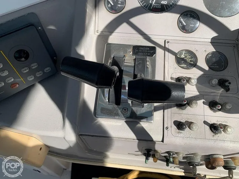 Slide: The Image of 1994 Cruisers Yachts Express Bridge control panel with throttle and gauges. - 20