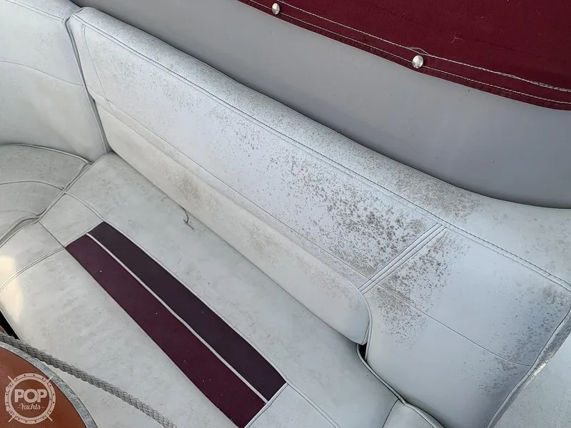 Slide: The Image of 1994 Cruisers Yachts Express Bridge interior with worn and stained white and maroon seating. - 27