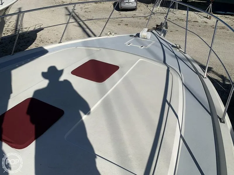 Slide: The Image of 1994 Cruisers Yachts Express Bridge deck with red cushions and railing. - 28