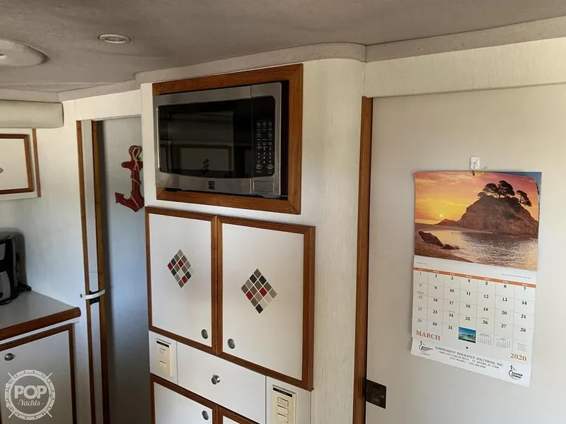 Slide: The Image of 1994 Cruisers Yachts Express Bridge interior with microwave and calendar. - 32