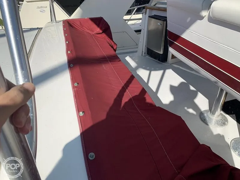 Slide: The Image of 1994 Cruisers Yachts Express Bridge deck with red cover and stainless steel railing. - 4