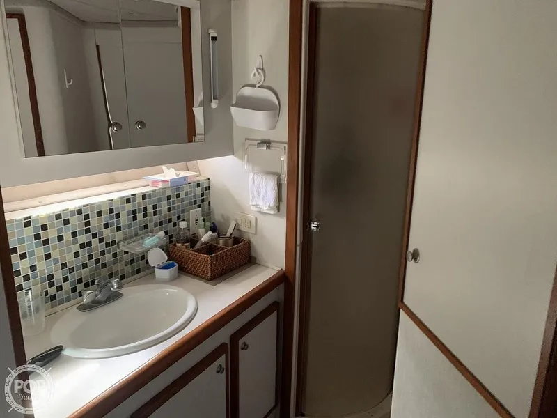 Slide: The Image of 1994 Cruisers Yachts Express Bridge bathroom with sink, mirror, and shower. - 45
