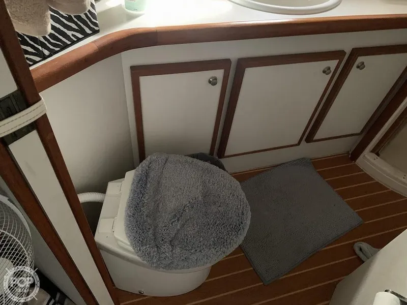 Slide: The Image of 1994 Cruisers Yachts Express Bridge bathroom with toilet, sink, and storage cabinets. - 48