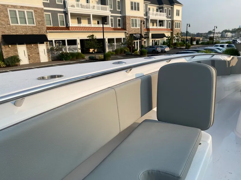 Slide: The Image of 2024 Cape Horn 34 XS boat with gray seating, docked near modern buildings. - 6