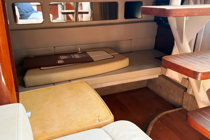 Slide: The Image of Interior cabin of a 2010 Sea Ray Sundancer 330, featuring seating and wooden table. - 17