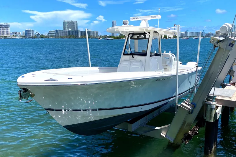 The Image of 2020 Regulator 31 boat docked on a lift in a marina. - 0