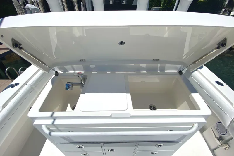 Slide: The Image of 2020 Regulator 31 boat with open storage compartments and sink. - 23