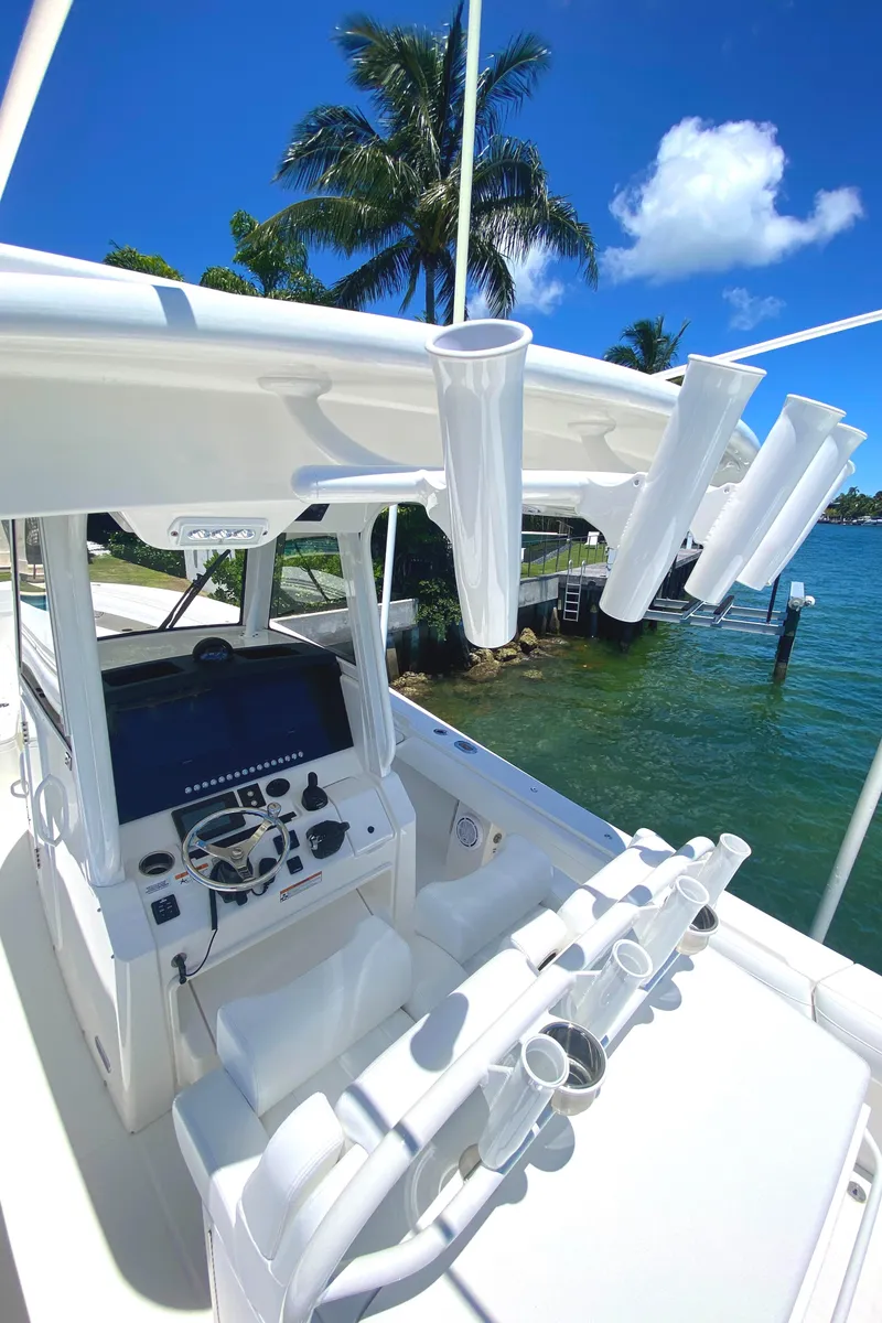 Slide: The Image of 2020 Regulator 31 boat with advanced navigation system and rod holders, docked by tropical waters. - 28