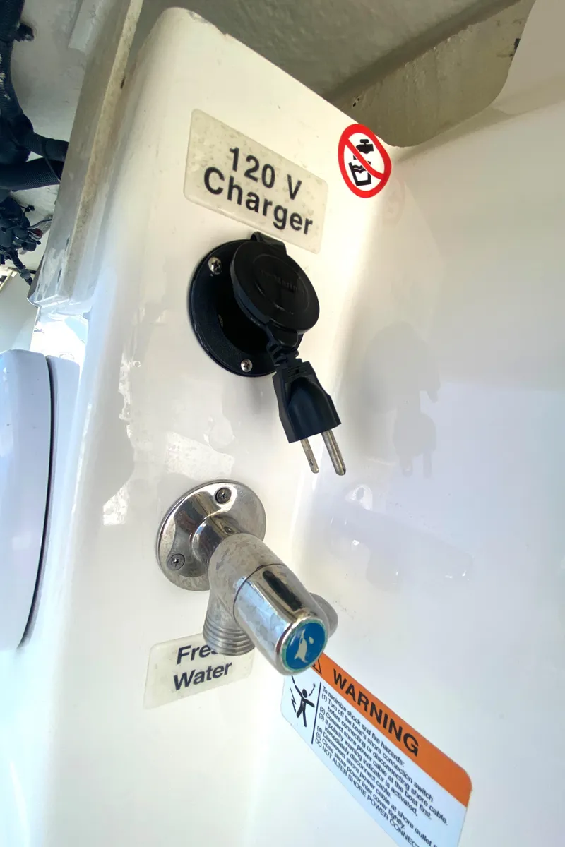 Slide: The Image of 120V charger and freshwater outlet on a 2020 Regulator 31 boat. - 47