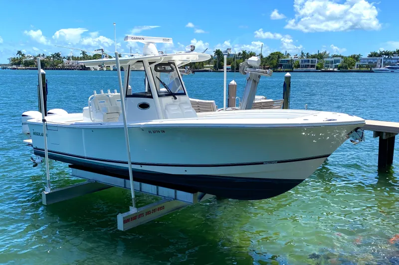 Slide: The Image of 2020 Regulator 31 boat docked on a lift in a sunny marina. - 5