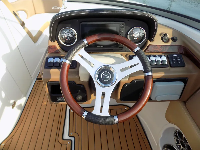 Slide: The Image of 2020 Crownline Eclipse E235 XS boat dashboard with wood-accented steering wheel and modern controls. - 10