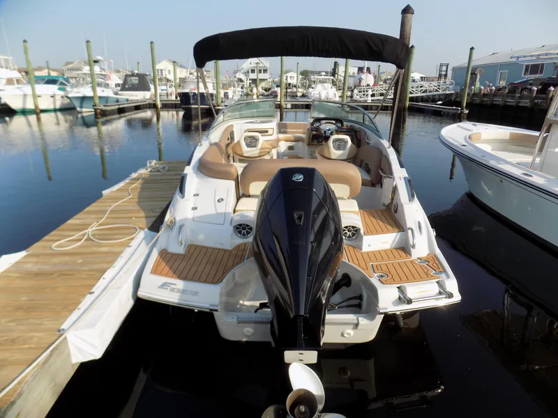 Slide: The Image of 2020 Crownline Eclipse E235 XS boat docked at marina, featuring sleek design and outboard motor. - 2