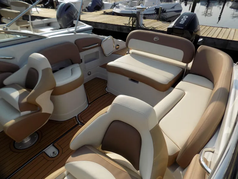 Slide: The Image of 2020 Crownline Eclipse E235 XS boat interior with beige seating and wood flooring. - 3