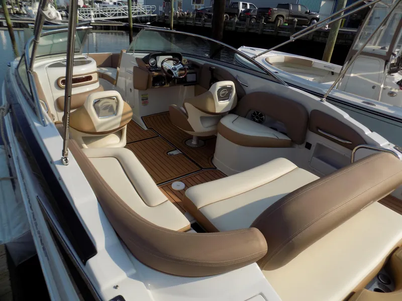 Slide: The Image of 2020 Crownline Eclipse E235 XS boat interior with beige seating and wood flooring. - 5
