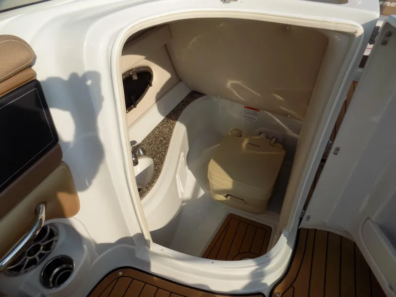 Slide: The Image of 2020 Crownline Eclipse E235 XS boat interior with compact bathroom and portable toilet. - 8