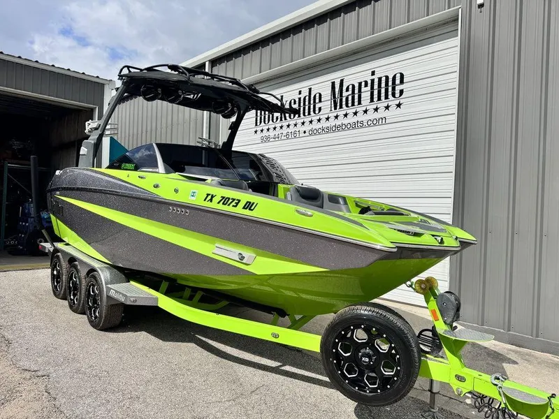 Slide: The Image of 2016 Malibu M235 boat in bright green on a trailer at Dockside Marine. - 1
