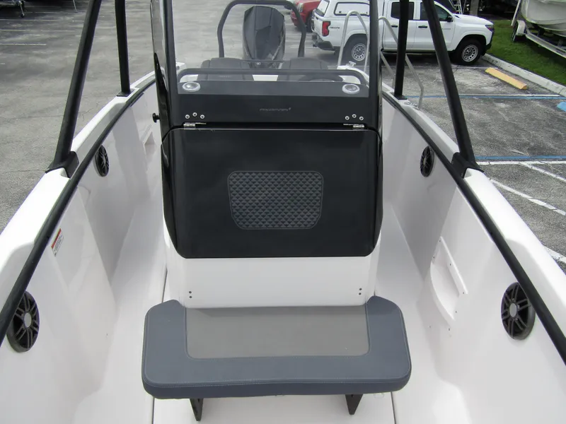 Slide: The Image of 2022 Axopar 22 T-Top boat interior with seating and dashboard view. - 9