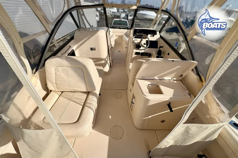 Slide: The Image of 2016 Grady-White Freedom 255 boat interior with beige seating and steering console. - 11