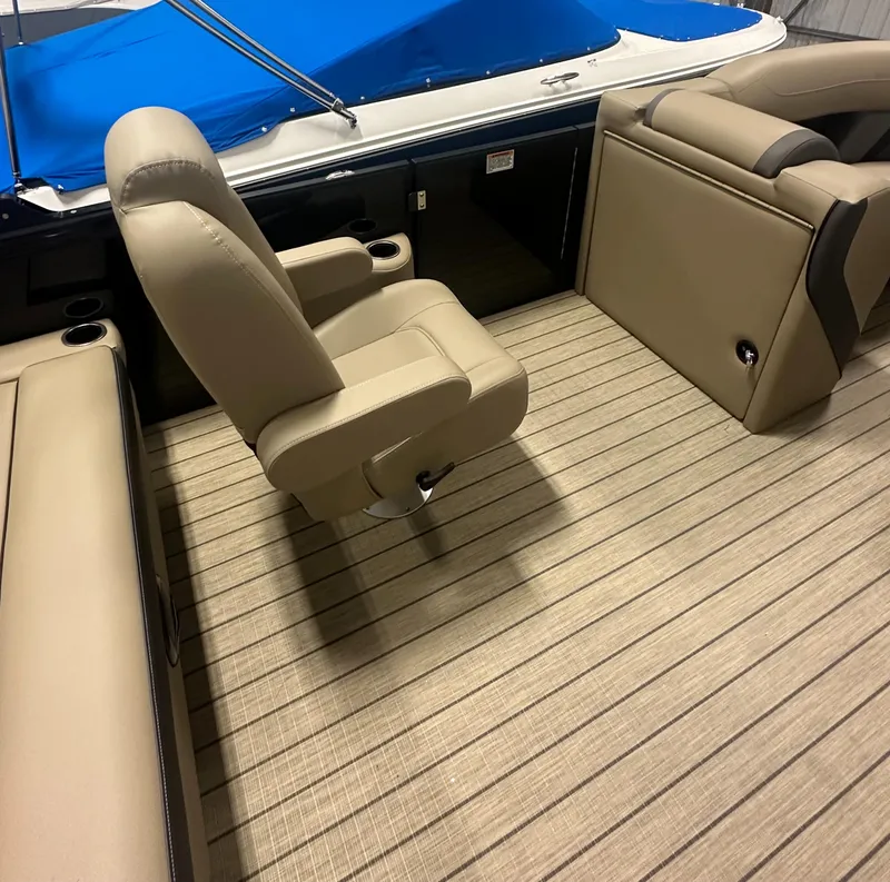 Slide: The Image of 2025 Sylvan MIRAGE X1 CLZ DH boat interior with beige seating and blue cover. - 12