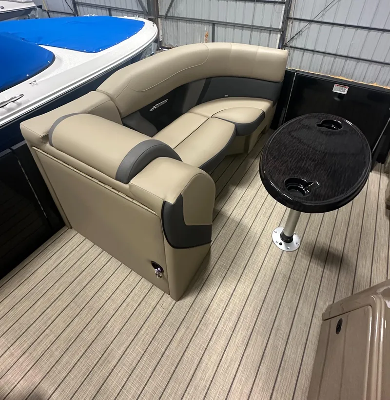 Slide: The Image of 2025 Sylvan MIRAGE X1 CLZ DH boat interior with beige seating and round table. - 16