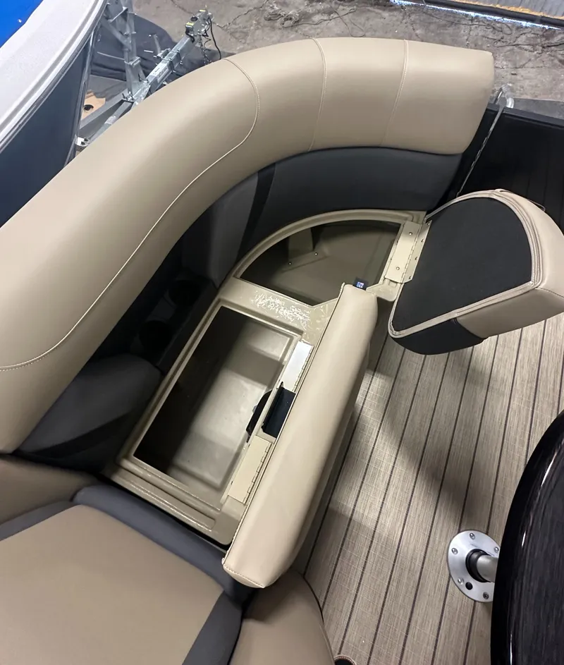 Slide: The Image of 2025 Sylvan MIRAGE X1 CLZ DH boat interior with open storage compartment and beige seating. - 17